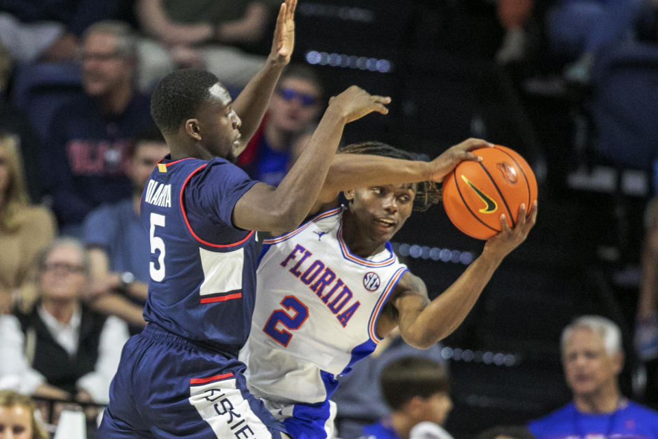 Florida guard Trey Bonham (2) is defended by Connecticut guard Hassan Diarra (5) during the first half of an NCAA college basketball game Wednesday, Dec. 7, 2022, in Gainesville, Fla. (AP Photo/Alan Youngblood)
