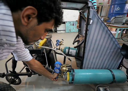 Mahmoud Yasser, mechanical engineering student from Helwan University, turns the valve of air tank on the air-powered vehicle which he helped design to promote clean energy and battle increasing gas prices, in Cairo, Egypt August 7, 2018. Picture taken August 7, 2018. REUTERS/Mohamed Abd El Ghany