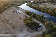 Official vehicles line a dirt road along the Rio Grande, Friday, Sept. 24, 2021, in Del Rio, Texas. (AP Photo/Julio Cortez)