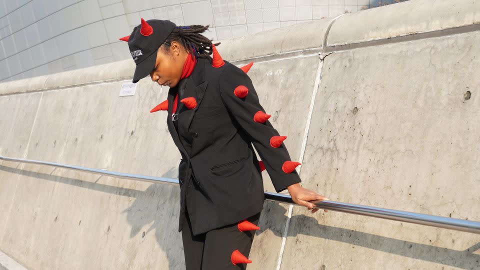 An attendee in an eye-catching black suit and a pair of platform sandals. - Soeun Kim/CNN