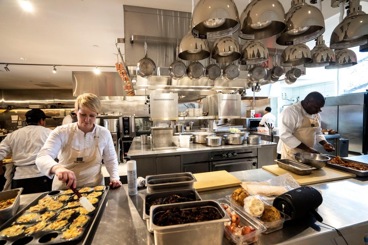 Jess Robertson, left, and her husband, Ian, prepare food at Oak Park in Des Moines.