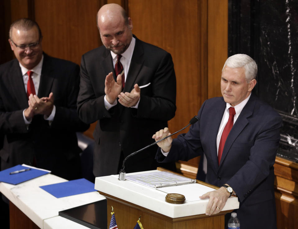 FILE - Indiana Gov. Mike Pence takes the podium to deliver his first State of the State address to a joint session of the legislature as Speaker of the House Brian C. Bosma, center, R-Indianapolis, and Senate President Pro Tem David Long, R-Fort Wayne, applaud at the Statehouse in Indianapolis, Jan. 22, 2013. As Mike Pence approaches a likely 2024 run for president, he's opening up to audiences about the parts of his career before he served as Donald Trump's vice president. He hopes his 12 years in Congress and four years as Indiana governor will project the record of a conservative fighter. (AP Photo/Michael Conroy, File)