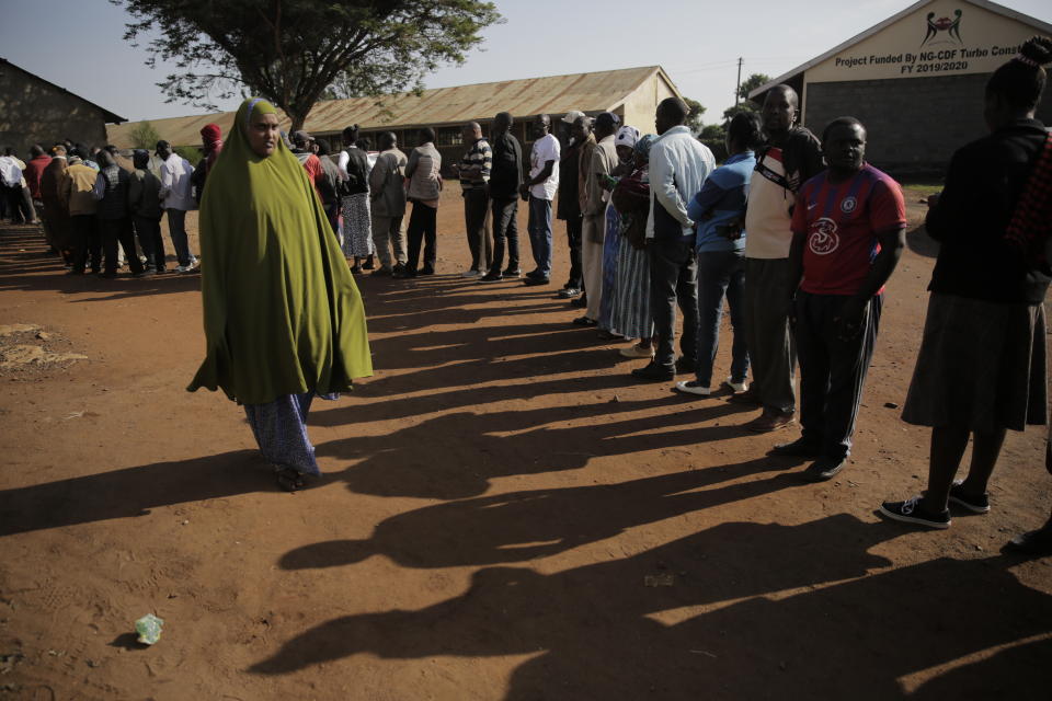 People line up to cast their vote in Kenya's general election in Sugoi, 50 kms (35 miles) north west of Eldoret, Kenya, Tuesday Aug. 9, 2022. Kenyans are voting to choose between opposition leader Raila Odinga Deputy President William Ruto to succeed President Uhuru Kenyatta after a decade in power. (AP Photo/Brian Inganga)