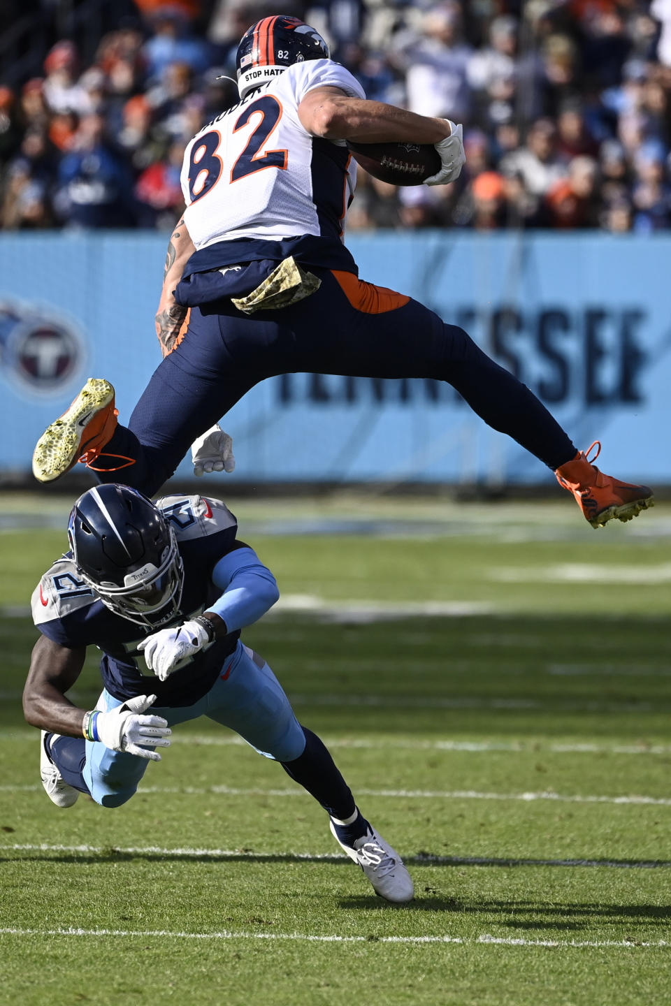 Denver Broncos tight end Eric Saubert (82) leaps over the tackle of Tennessee Titans cornerback Roger McCreary (21) during the second half of an NFL football game, Sunday, Nov. 13, 2022, in Nashville, Tenn. (AP Photo/Mark Zaleski)