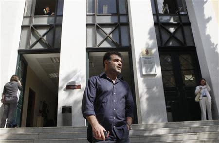 Greek investigative journalist Costas Vaxevanis (C) leaves a courthouse in Athens October 8, 2013. REUTERS/John Kolesidis