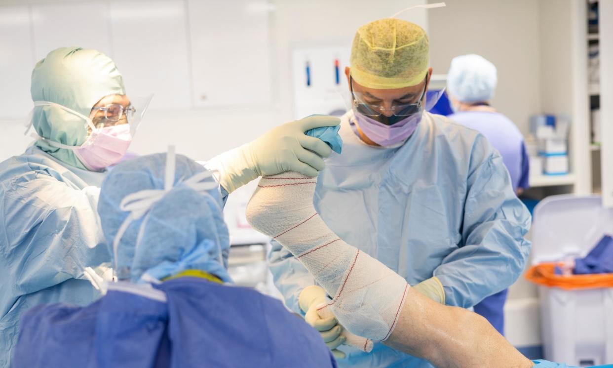 <span>Dusty Springfield plays softly in the background … surgeon Mohammad Faisal at work.</span><span>Photograph: Graeme Robertson/The Guardian</span>