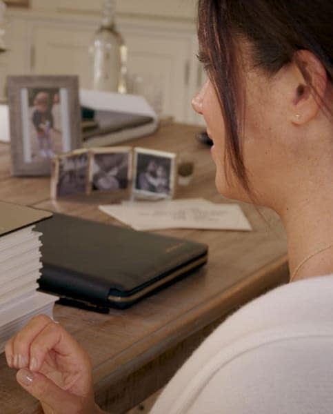 Meghan Markle sat at desk with family photos