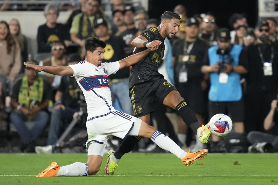 Vancouver Whitecaps defender Ranko Veselinovic, left, defends against Los Angeles FC forward Denis Bouanga (99) during the second half of an MLS soccer match in Los Angeles, Saturday, June 24, 2023. (AP Photo/Ashley Landis)