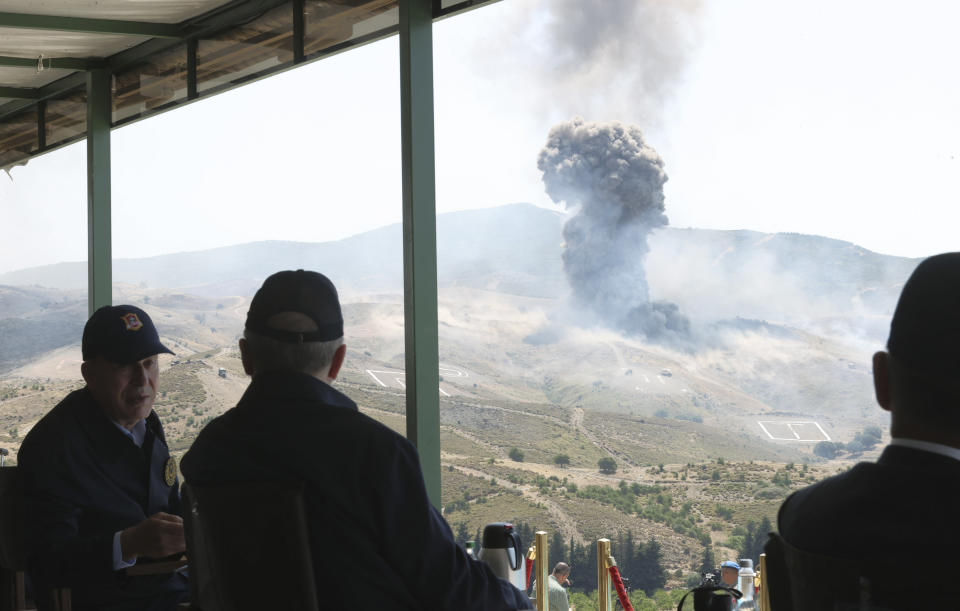 In this handout photo provided by the Turkish Presidency, Turkish President Recep Tayyip Erdogan, center, speaks with Defense Minister Hulusi Akar during the final day of military exercises that were taking place in Seferihisar near Izmir, on Turkey's Aegean coast, Thursday, June 9, 2022. Erdogan on Thursday warned Greece to demilitarize islands in the Aegean, saying he was "not joking" with such comments. Turkey says Greece has been building a military presence on Aegean in violation of treaties that guarantee the unarmed statues of the islands. (Turkish Presidency via AP)