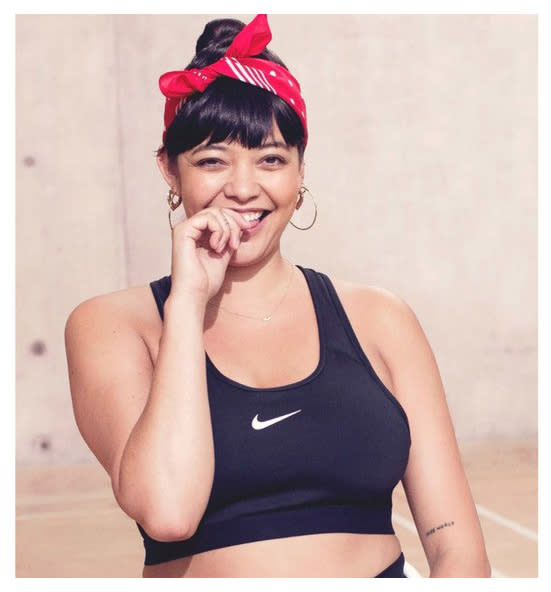 A model with a red bandana in her hair wears a Nike athletic top.