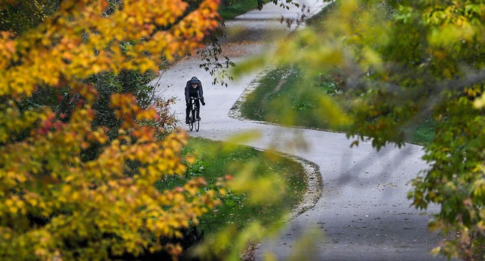 A bicyclist rides past fall colored leaves at Riverside Park in Milwaukee on Oct. 28, 2021.