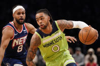 Minnesota Timberwolves guard D'Angelo Russell (0) drives against Brooklyn Nets guard Patty Mills (8) during the first half of an NBA basketball game Friday, Dec. 3, 2021, in New York. (AP Photo/Mary Altaffer)