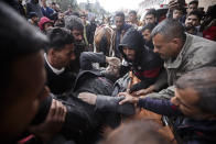 Palestinians evacuate a wounded man after an Israeli strike in Kahan Younis, Gaza Strip, Friday, Jan. 12, 2024. AP Photo/Mohammed Dahman)