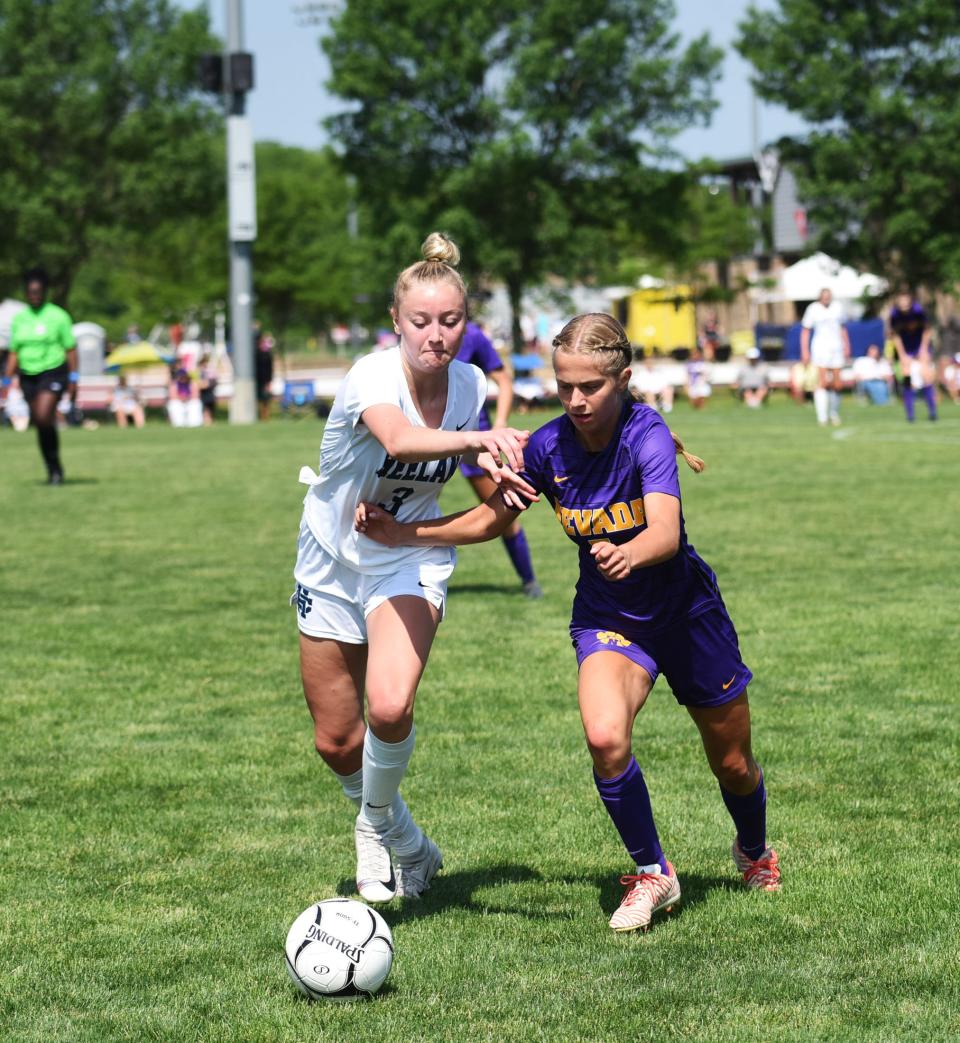 Nevada midfielder Vanessa Reid and Bishop Heelan midfielder Addison Kuehl race to the ball during the first half of the Class 1A girls soccer state quarterfinal game between the Cubs and Crusaders Wednesday at the Cownie Soccer Park in Des Moines.