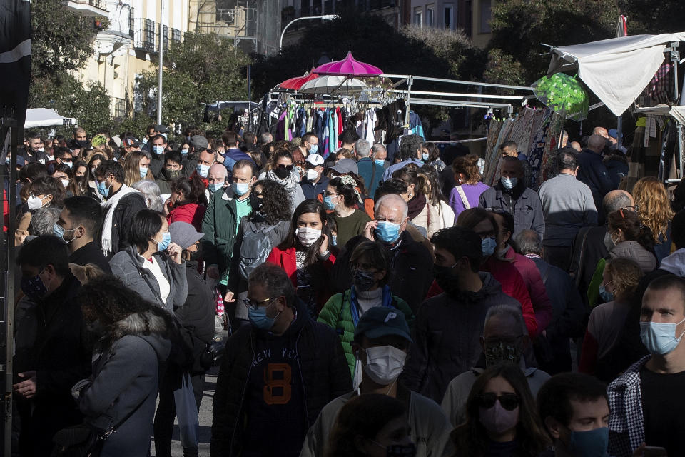 People walk in the Rastro flea market in Madrid, Spain, Sunday, Nov. 22, 2020. Madrid's ancient and emblematic Rastro flea market reopened Sunday after a contentious eight-month closure because of the COVID-19 pandemic that has walloped the Spanish capital. (AP Photo/Paul White)