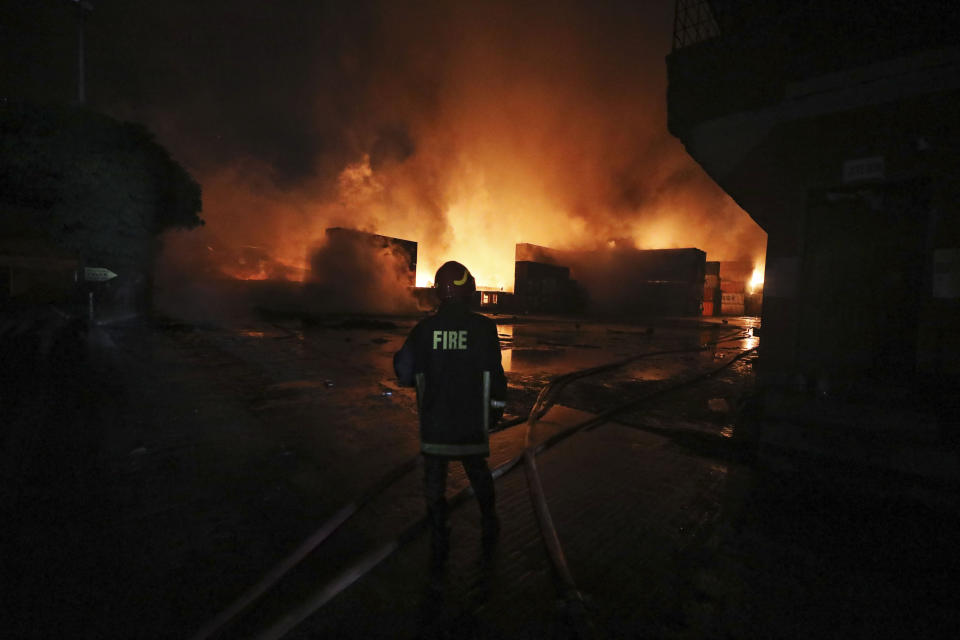 Un bombero trabaja para contener un incendio en el BM Inland Container Depot, un depósito de contenedores con participación holandesa y bangladeshí, en Chittagong, 216 kilómetros (134 millas) al sur de la capital, Daca, Bangladesh, la madrugada del domingo 5 de junio de 2022. (AP Foto)