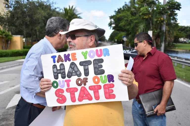 Bud Conlin holds a sign outside the Trump Doral National hotel and Spa in Miami, Florida on July 26, 2016 where Republican Presidential nominee Donald Trump held a fundraiser