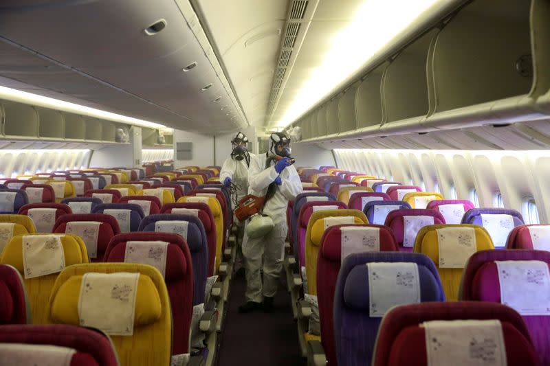 Members of the Thai Airways crew disinfect the cabin of an aircraft of the national carrier during a procedure to prevent the spread of the coronavirus at Bangkok's Suvarnabhumi International Airport