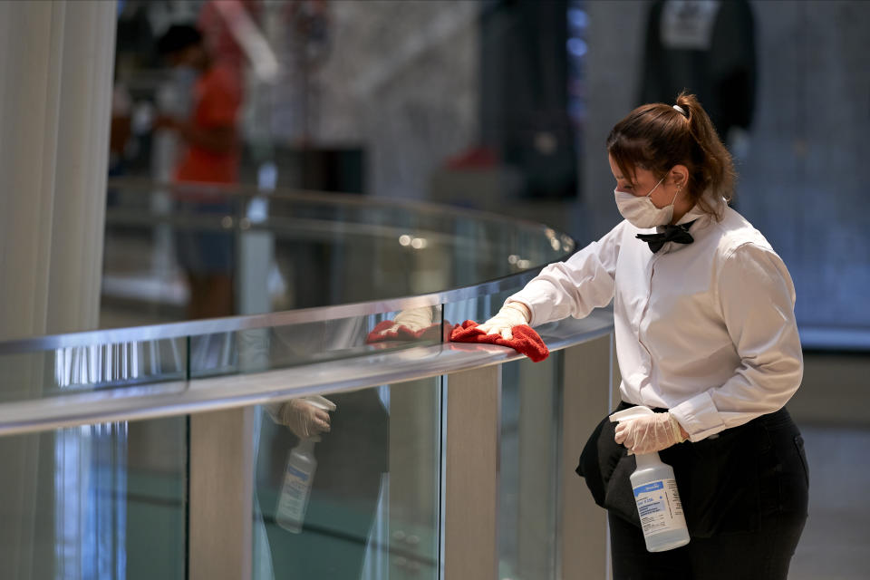 A worker disinfects hand rails at the Galleria Dallas mall in Dallas, Texas on May 4, 2020. | Cooper Neill—Bloomberg/Getty Images