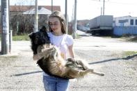 Ana-Maria Ciulcu takes a dog from a street in Bucharest March 15, 2014. Ana-Maria is just 13 years old and she had the idea of using social media to find people willing to adopt a stray dog. Different from other children her age, she uses all her free time to save stray dogs. Her Facebook page turned into an adoption centre, very successful until now, with more than 150 dogs sent abroad to animal lovers mainly from Germany, Austria and Belgium. Picture taken March 15, 2014. REUTERS/Bogdan Cristel (ROMANIA - Tags: ANIMALS SOCIETY)