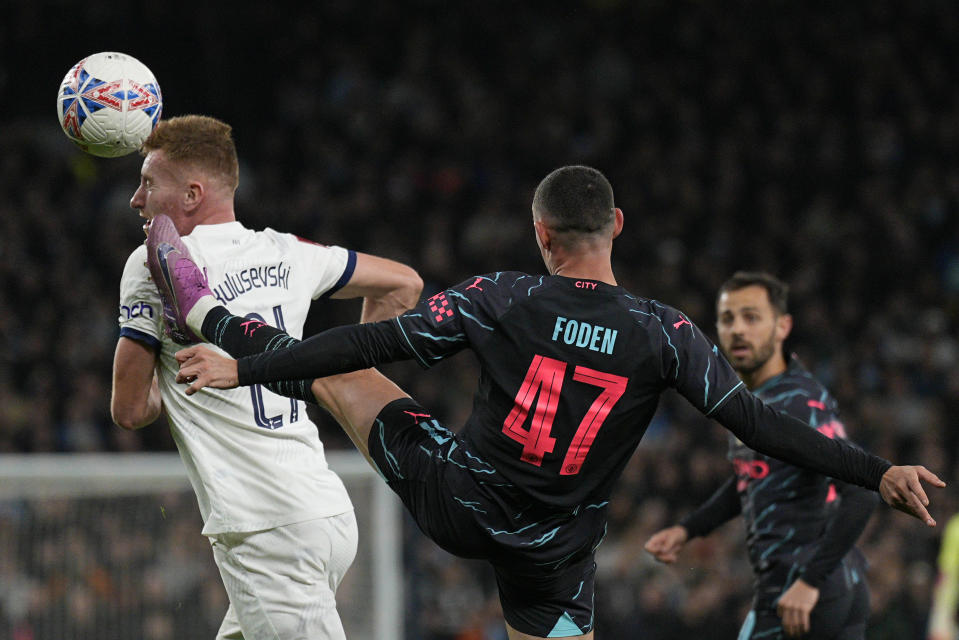 Manchester City's Phil Foden challenges Tottenham's Dejan Kulusevski during the English FA Cup fourth round soccer match between Tottenham Hotspur and Manchester City in London, Friday, Jan. 26, 2024. (AP Photo/Dave Shopland)