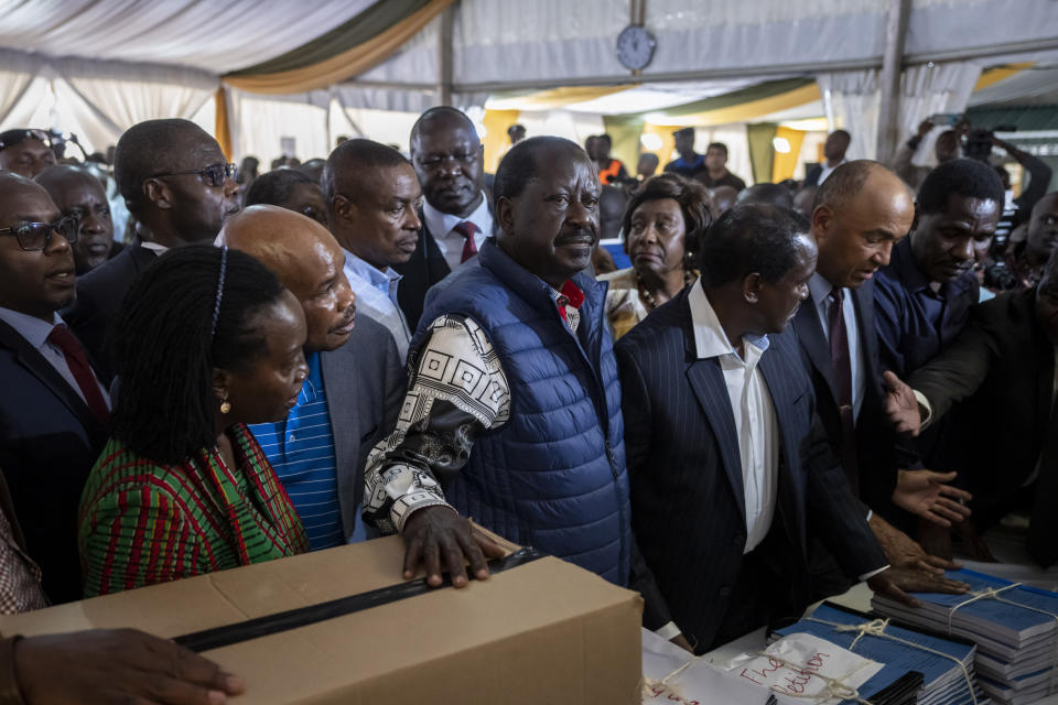 Presidential candidate Raila Odinga, center, hands over the petition and boxes of evidence to the Supreme Court challenging the election results, accompanied by running mate Martha Karua, left, in Nairobi, Kenya Monday, Aug. 22, 2022. Odinga filed a Supreme Court challenge to last week's election result, asserting that the process was marked by criminal subversion and seeking that the outcome be nullified and a new vote be ordered. (AP Photo/Ben Curtis)