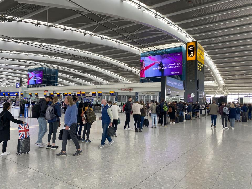 Passengers queue to go through security in departures at Terminal 5 of Heathrow Airport.