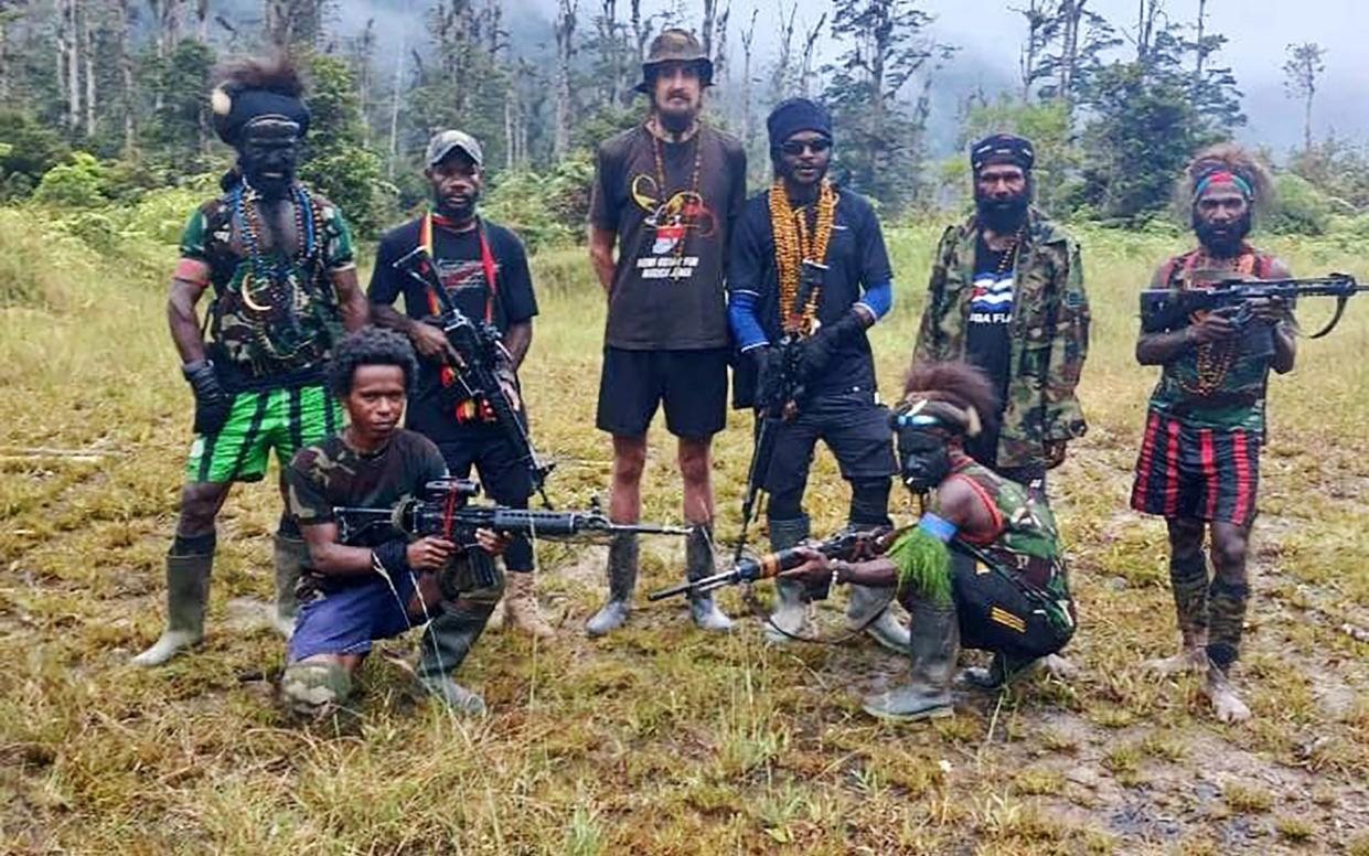 Phillip Mehrtens with his abductors who captured the pilot when he attempted to pick up construction workers in the remote region of Nduga