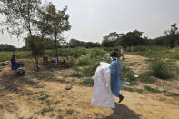 A man wearing personal protective equipment carries the body of his three-month-old son who died of COVID-19 in New Delhi, India, Wednesday, Sept. 16, 2020. India is now second in the world with the number of reported coronavirus infections with over 5.1 million cases, behind only the United States. Its death toll of only 83,000 in a country of 1.3 billion people, however, is raising questions about the way it counts fatalities from COVID-19. (AP Photo/Manish Swarup)