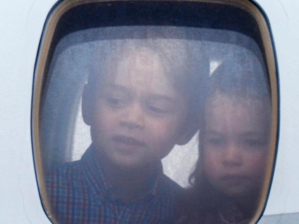 Princess Charlotte of Cambridge and Prince George of Cambridge look out of the window of the plane as they arrive at Warsaw airport.
