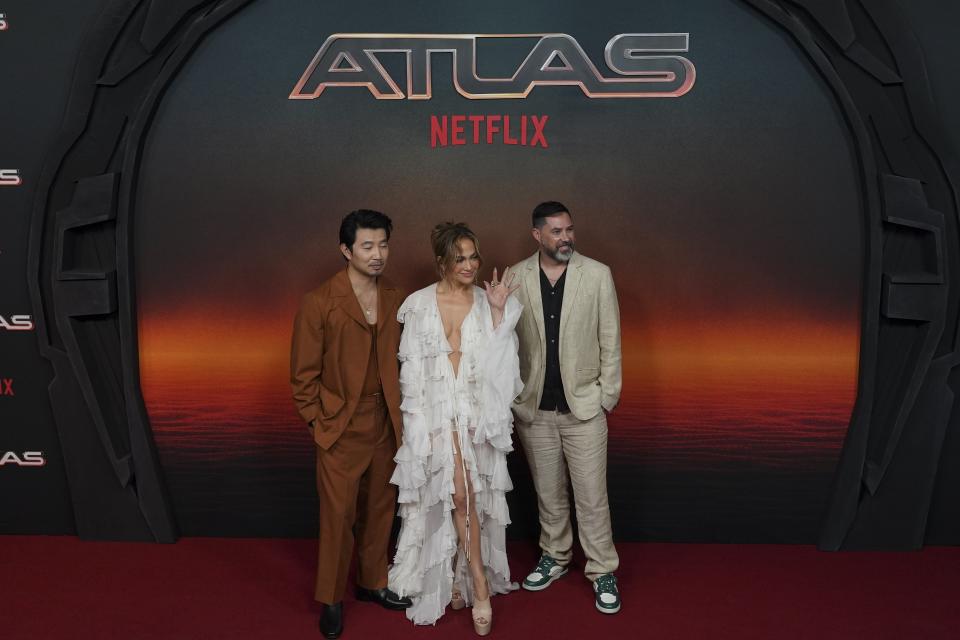 El actor Simu Liu, izquierda, la actriz Jennifer Lopez, centro, y el director Brad Peyton posan en un evento promocional de la película de Netflix ATLAS en la Ciudad de México el martes 21 de mayo de 2024. (Foto AP/Marco Ugarte)