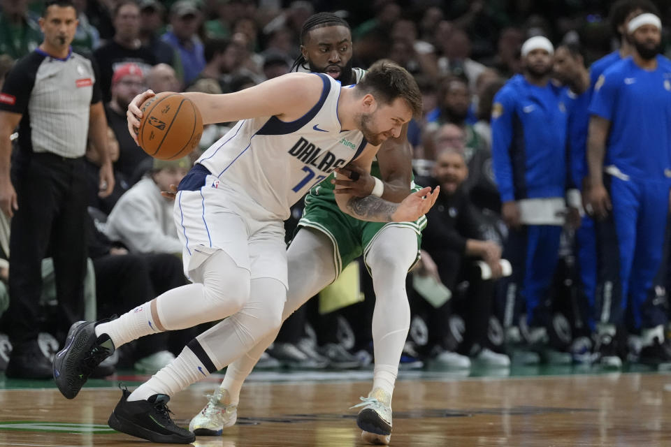 Dallas Mavericks guard Luka Doncic, front, drives with the ball as Boston Celtics guard Jaylen Brown, back, defends during the first half of Game 5 of the NBA basketball finals, Monday, June 17, 2024, in Boston. (AP Photo/Charles Krupa)