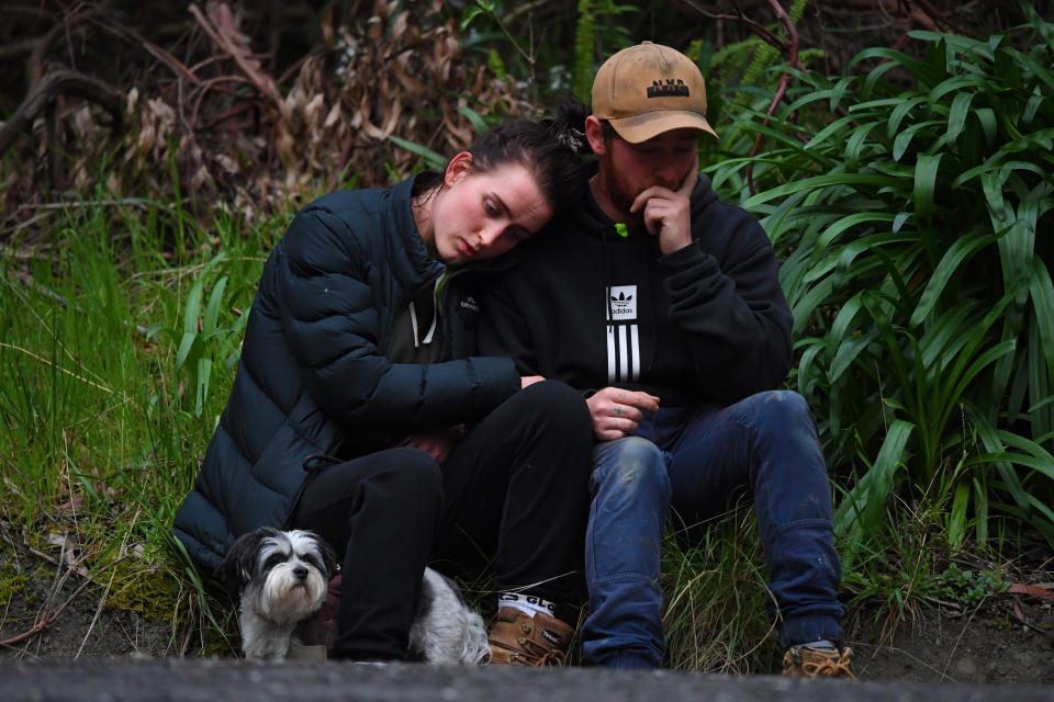 Two people sit on the roadside after the discovery of William's body. Source: AAP