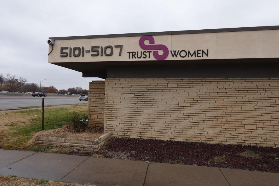 The exterior of the Trust women's clinic, with no windows and beige brick.