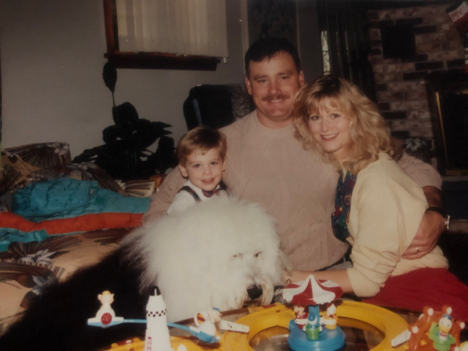 Zachary Ludwig, his parents and their dog pose for a photo.