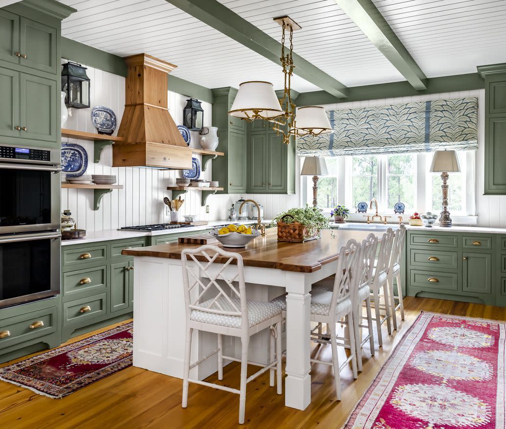 kitchen with soothing green painted cabinets, rafters, and trim paired with white paneled walls, ceiling, and island