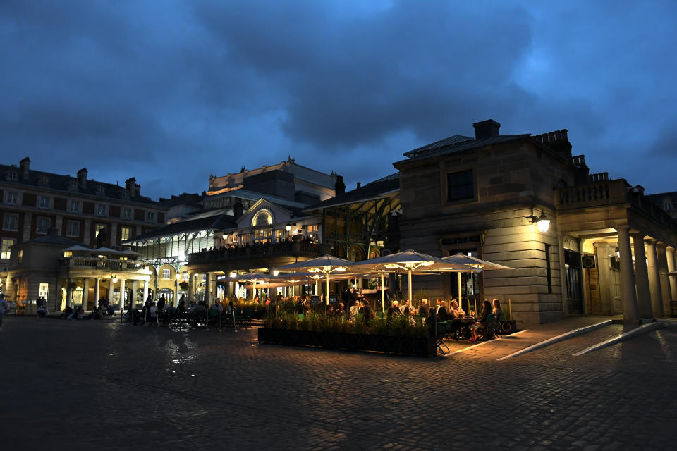 People eat and drink in Covent Garden, in London, Tuesday, Sept. 22, 2020. Britain's Prime Minister, Boris Johnson, has announced that pubs and restaurants closing at 10pm, due to the spike of cases of coronavirus across the United Kingdom. (AP Photo/Alberto Pezzali)