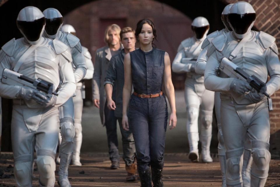 This image released by Lionsgate shows Jennifer Lawrence as Katniss Everdeen, from foreground to background, Josh Hutcherson as Peeta Mellark and Woody Harrelson as Haymitch Abernathy in a scene from "The Hunger Games: Catching Fire." (AP Photo/Lionsgate, Murray Close)