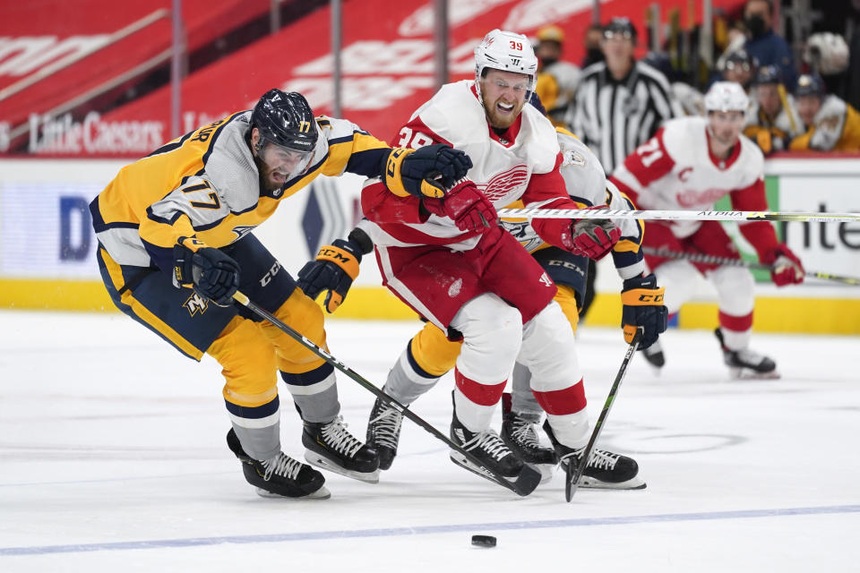 Nashville Predators defenseman Ben Harpur (17) and Detroit Red Wings right wing Anthony Mantha (39) chase a loose puck in the second period of an NHL hockey game Tuesday, April 6, 2021, in Detroit. (AP Photo/Paul Sancya)