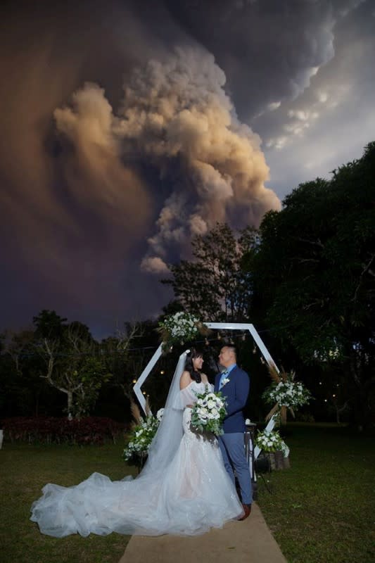 Social media image of a couple attending their wedding ceremony as Taal Volcano sends out a column of ash in the background in Alfonso, Cavite, Philippines