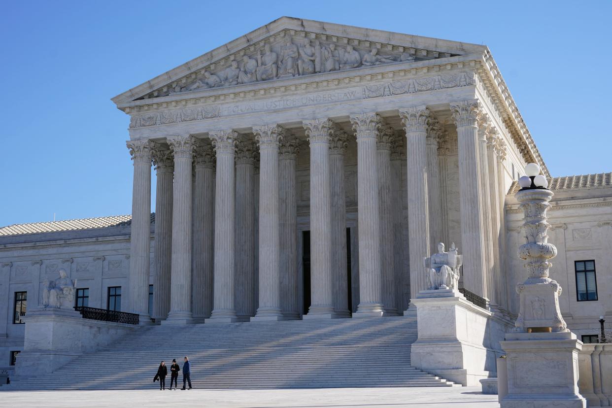 Visitors walk outside the U.S. Supreme Court building on Capitol Hill on Feb. 21, 2022, in Washington.