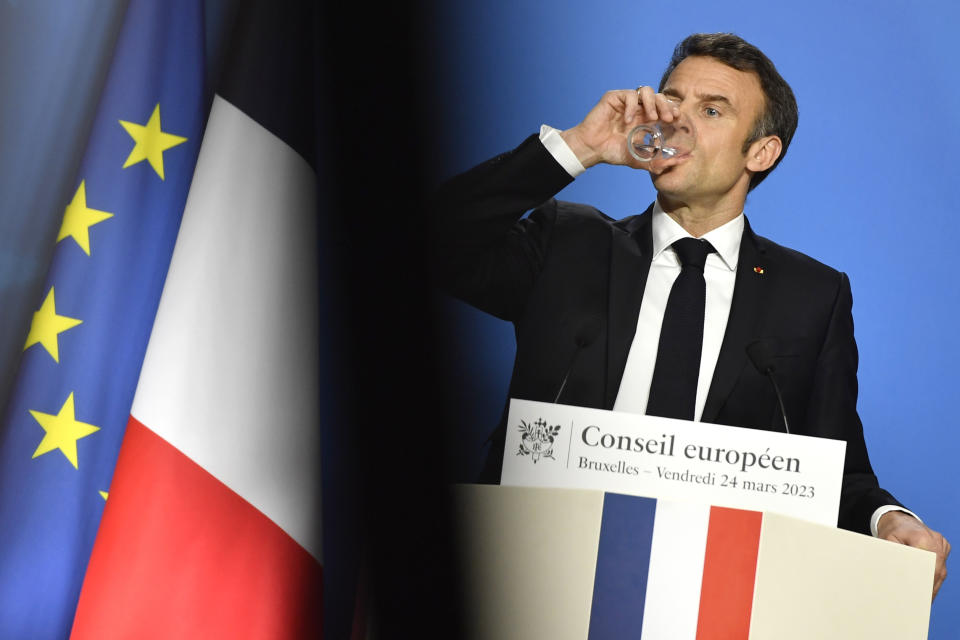 France's President Emmanuel Macron takes a drink of water as he answers questions during a media conference at an EU summit in Brussels, Friday, March 24, 2023. European leaders gathered Friday to discuss economic and financial challenges and banking rules, seeking to tamp down concerns about eventual risks for European consumers from banking troubles in the US and Switzerland. (AP Photo/Geert Vanden Wijngaert)