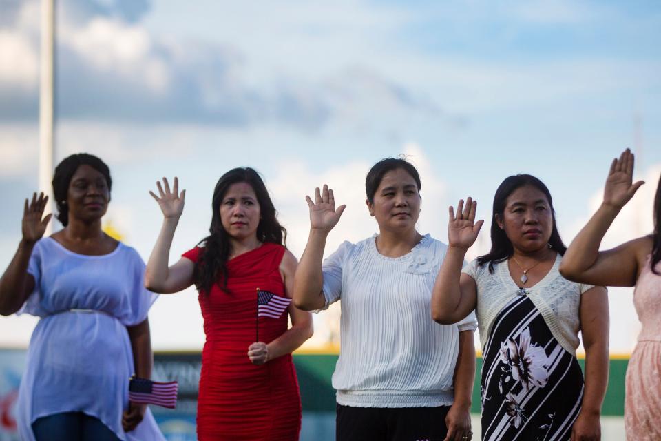 New American citizens line up before taking the pledge of allegiance at the Iowa Cubs’ annual citizenship ceremony on July 4, 2019, in Principal Park. A total of 30 people from 14 countries became citizens.