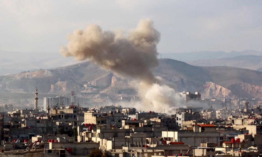 Smoke rises after Syrian regime aircraft carried out airstrikes on a town in the eastern Ghouta region near Damascus on 5 March.