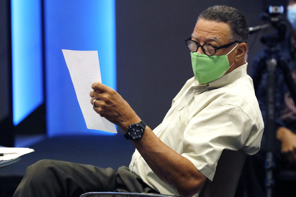 Former Mississippi Supreme Court Justice Reuben Anderson reviews the agenda of at the first meeting of the Flag Commission, Wednesday, July 22, 2020 in Jackson, Miss. Anderson was elected to chair the commission by its members. The group has the duty to design a new Mississippi state flag without the Confederate battle emblem and the banner must include the phrase, "In God We Trust." (AP Photo/Rogelio V. Solis)