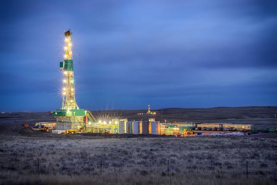 A drilling rig at night in a desert setting. 
