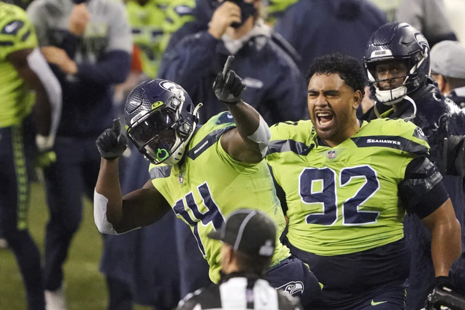 Seattle Seahawks' Bryan Mone (92) cheers on DK Metcalf (14) after Metcalf pulled in a long pass near the end of the second half of an NFL football game against the Minnesota Vikings, Sunday, Oct. 11, 2020, in Seattle. The Seahawks won 27-26. (AP Photo/Ted S. Warren)