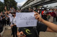 A pro-democracy activist displays a placard during a demonstration at Kaset intersection, suburbs of Bangkok, Thailand, Monday, Oct. 19, 2020. Thailand's embattled Prime Minister Prayuth Chan-ocha said Monday that there were no plans to extend a state of emergency outside the capital, even as student-led protests calling for him to leave office spread around the country. Placard reads as "release my friends" (AP Photo/Sakchai Lalit)