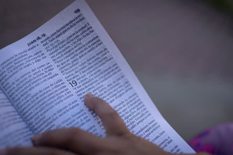 An Ecuadorean migrant reads from a Bible