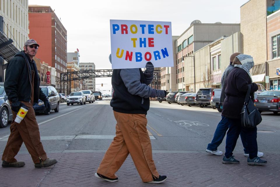 Anti-abortion signs are held by supporters during a Kansans for Life march through downtown Topeka, Kansas on Jan. 25, 2022.